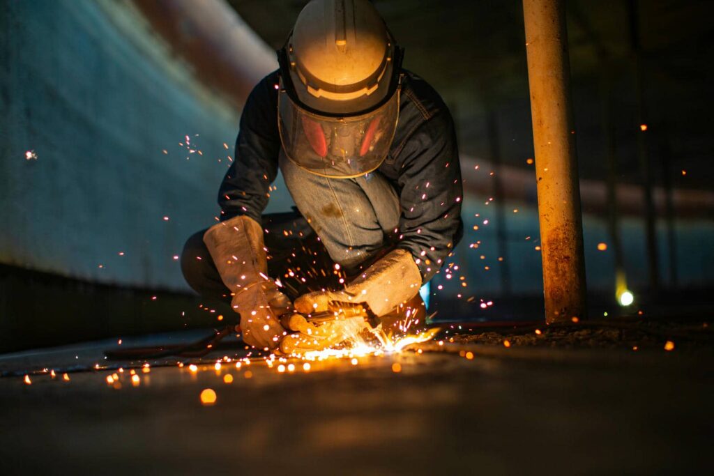 Metal welder creating sparks in dark environment