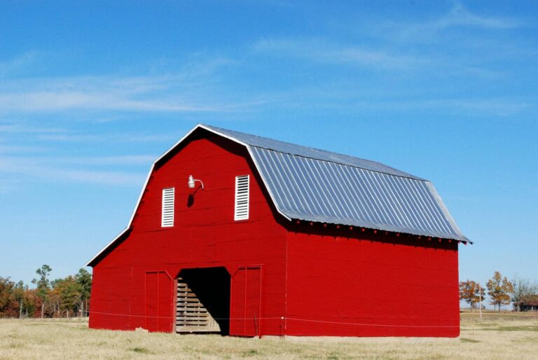 Bright red metal barn under clear blue sky