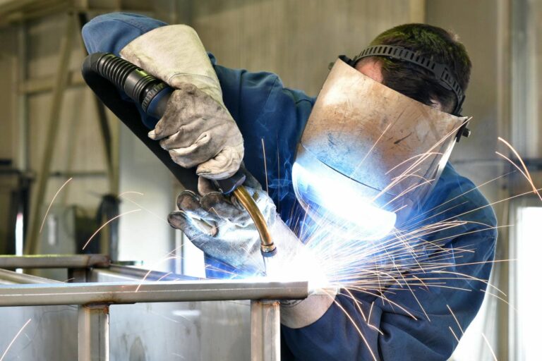 Welder creating metal structure with sparks