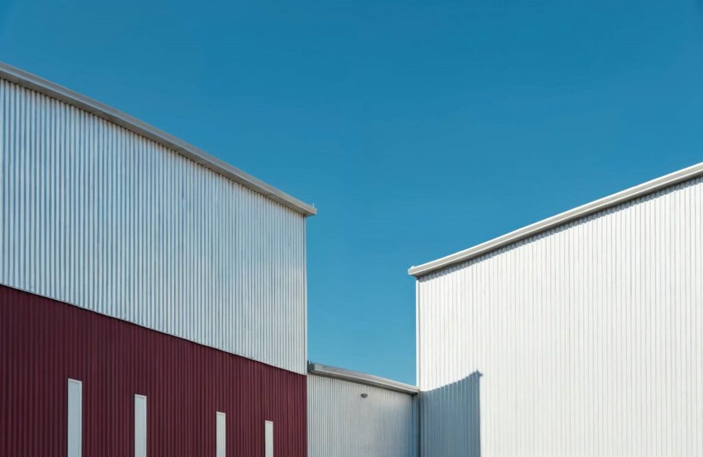 Two metal buildings under clear blue sky