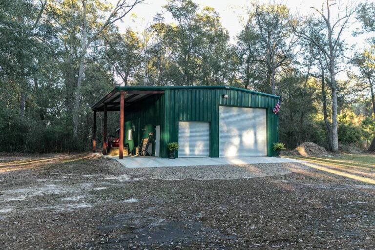 Green metal garage in wooded area