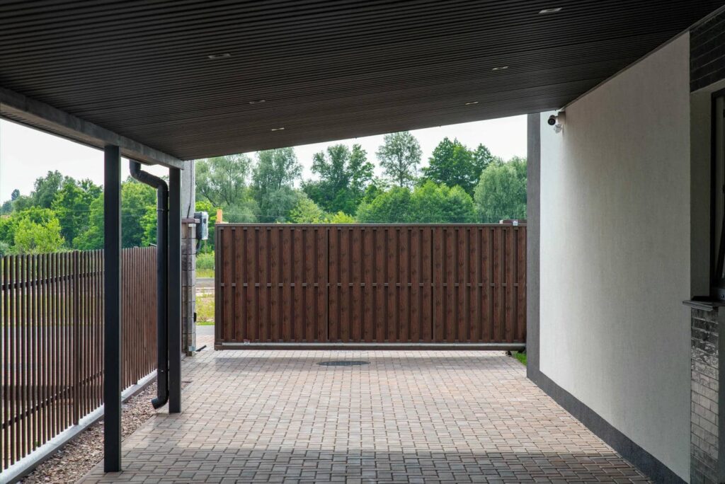 Metal covered parking area with fence.